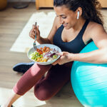 Sporty young woman eating healthy food