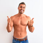 Young handsome shirtless man showing muscular body